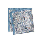 A folded square silk pocket square featuring a blue and beige paisley pattern with a solid light blue border, displayed on a clean white background. Eton Pocket Square available at Sakks Menswear in Southampton.