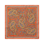 A square scarf with a vibrant orange background, featuring a detailed paisley pattern in gold, green, purple, and blue, finished with a decorative border. Eton Pocket Square available at Sakks Menswear in Southampton.