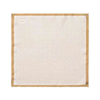 A square white pocket square with a repeating geometric pattern and a tan border, featuring the brand name 'ETON' printed in the top left corner. Eton Pocket Square available at Sakks Menswear in Southampton.
