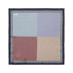 A square pocket square with a four-quadrant patterned design in light blue, lavender, rust red, and beige, framed by a dark navy border with a decorative geometric pattern. Eton Pocket Square available at Sakks Menswear in Southampton.
