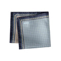 A folded square silk pocket square with a light blue and gray geometric pattern, dark navy borders, and gold accents, featuring the brand name 'ETON' printed in the top left corner. Eton Pocket Square available at Sakks Menswear in Southampton.