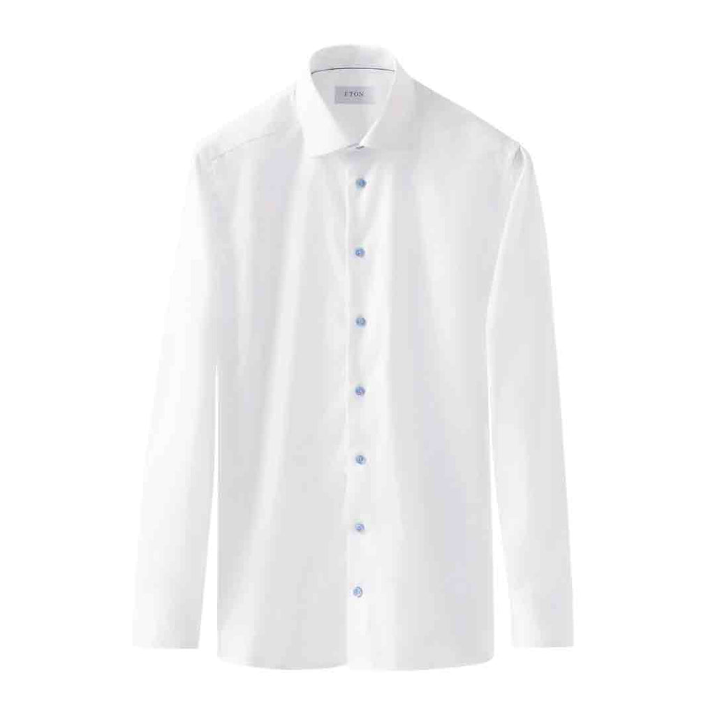 A white long-sleeve button-down dress shirt with a classic collar and light blue buttons, shown against a plain white background. Eton Shirt available at Sakks Menswear in Southampton.