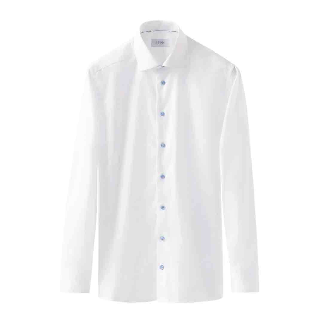 A white long-sleeve button-down dress shirt with a classic collar and light blue buttons, shown against a plain white background. Eton Shirt available at Sakks Menswear in Southampton.