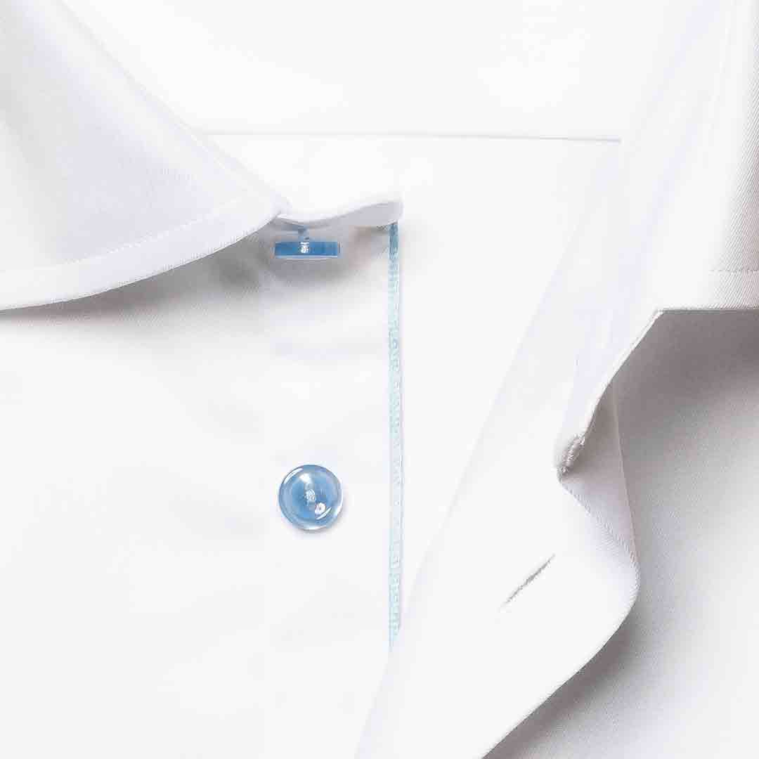 Close-up of a white dress shirt collar with a single light blue button and a thin light blue stripe detail along the placket. Eton Shirt available at Sakks Menswear in Southampton.