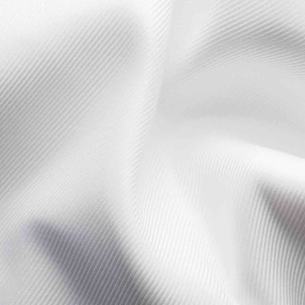 A close-up of white textured fabric with a fine diagonal ribbed pattern and soft folds. Eton Shirt available at Sakks Menswear in Southampton.