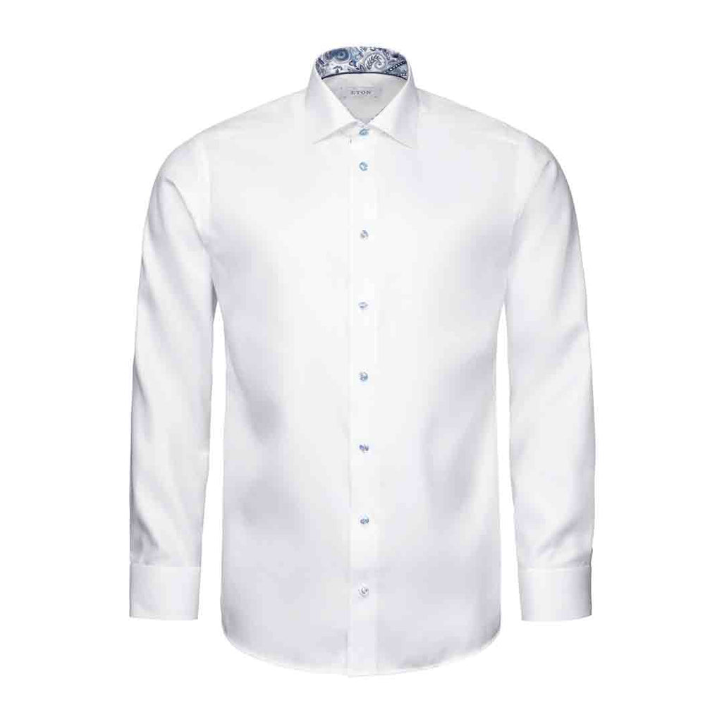 A white long-sleeve dress shirt with a pointed collar, button-down front, and a blue paisley patterned inner collar, shown on a plain white background. Eton Shirt available at Sakks Menswear in Southampton.