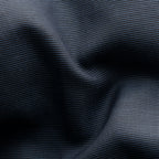 A close-up of dark charcoal gray fabric with a fine woven texture and soft folds. Eton Shirt available at Sakks Menswear in Southampton.