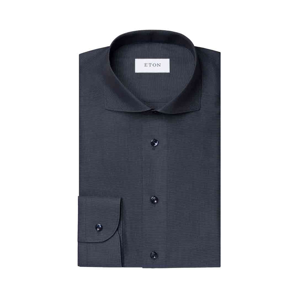 A dark charcoal gray ETON dress shirt folded neatly, showing a classic collar, button-down front, and a single cuff with a button, set against a plain white background. Eton Shirt available at Sakks Menswear in Southampton.
