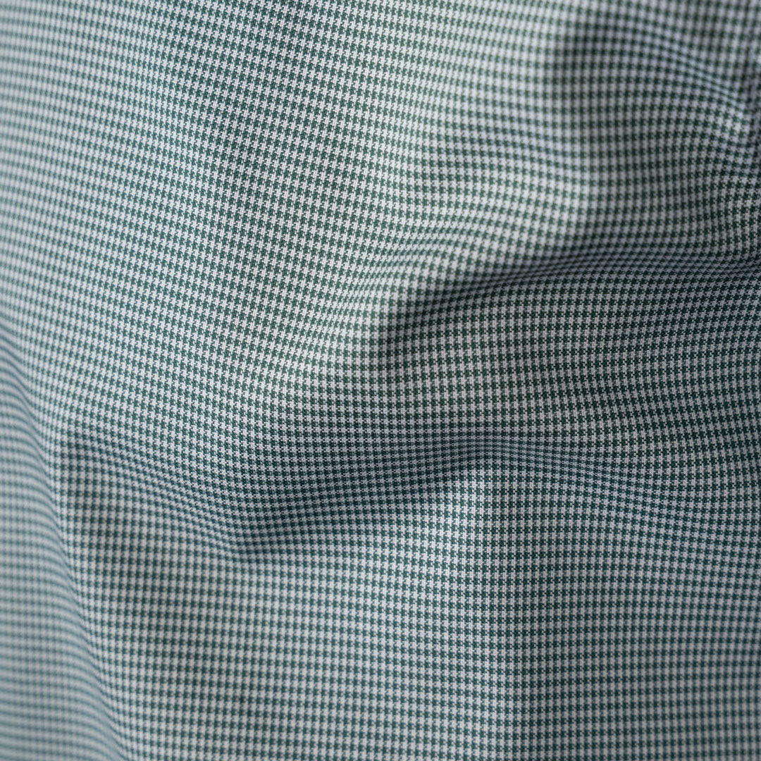 Close-up of a fine micro-check fabric pattern in light green and white, showing soft folds and texture.  Eton Shirts available at Sakks Menswear in Southampton.