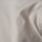Close-up of a fine micro-check fabric pattern in beige and white, showing soft folds and texture.  Eton shirts available at Sakks Menswear in Southampton.