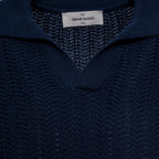 Close-up of a dark navy blue knit sweater with a textured pattern and a white brand label reading 'GRAN SASSO' at the collar. Gran Sasso Polo available at Sakks Menswear in Southampton.