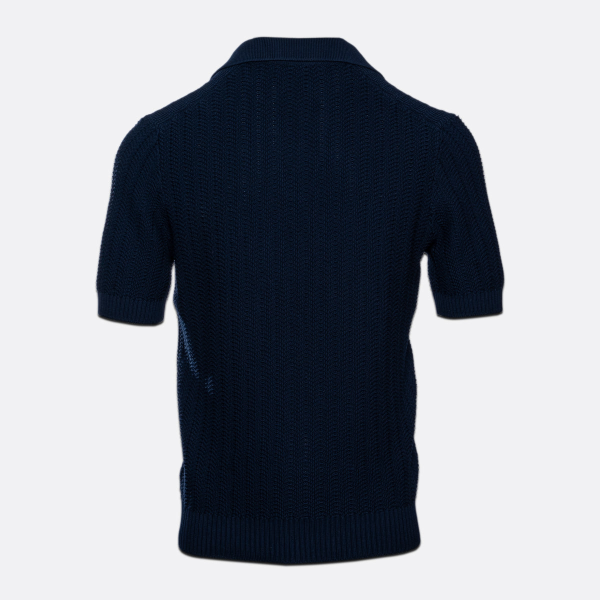 A dark navy blue short-sleeve knit polo shirt shown from the back, featuring a textured waffle-knit pattern and ribbed collar, cuffs, and hem, set against a plain light grey background. Gran Sasso Polo available at Sakks Menswear in Southampton.