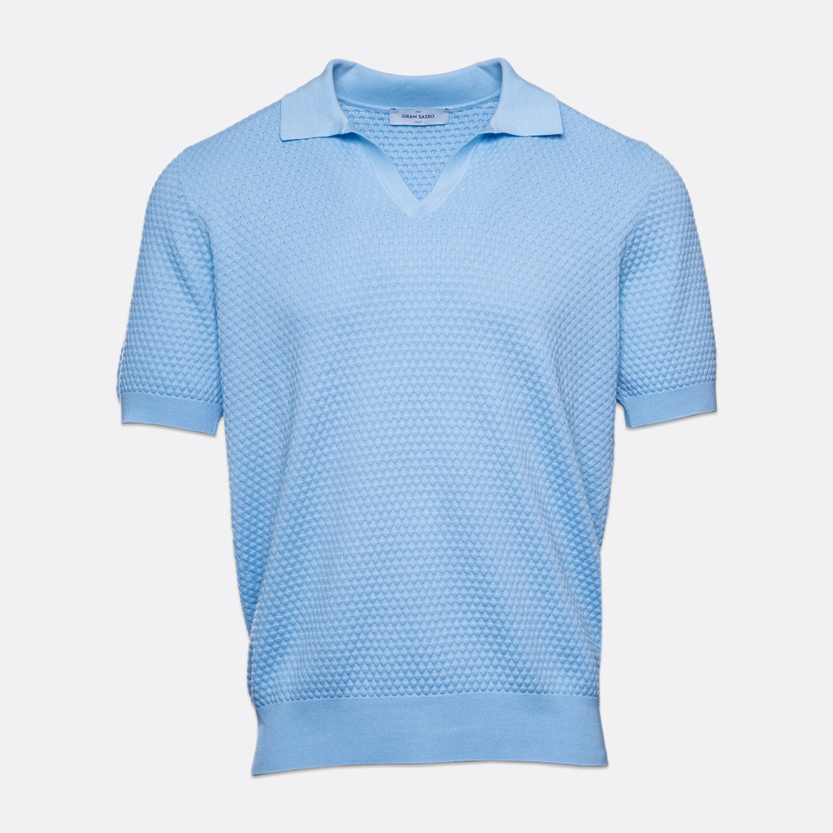 A light blue short-sleeve knit polo shirt with a textured micro-dot pattern, displayed on a clean, light grey background. Gran Sasso Polo available at Sakks Menswear in Southampton.