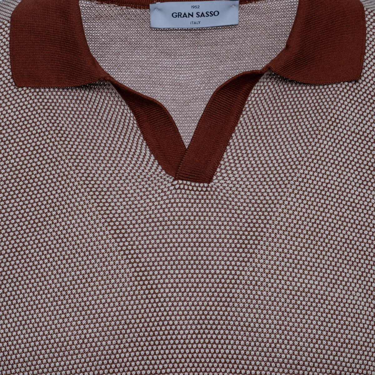 Close-up of a textured knit polo shirt by Gran Sasso, featuring a brown ribbed collar and V-neck trim over a fine beige and brown micro-patterned body. Gran Sasso Polo available at Sakks Menswear in Southampton.