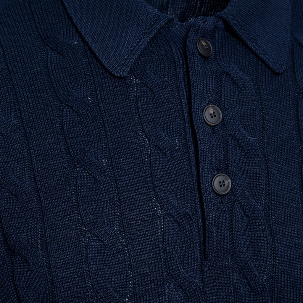 Close-up of a dark navy blue cable-knit polo shirt showing the collar, three buttons, and detailed knit texture. Gran Sasso Polo available at Sakks Menswear in Southampton.