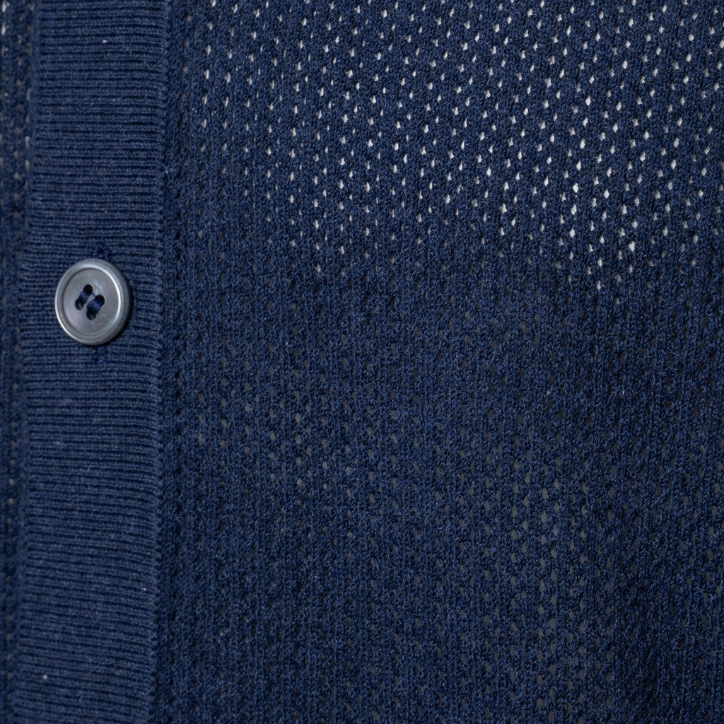 Close-up of a navy blue knit cardigan or sweater showing the ribbed button placket, a single silver button, and a textured dotted knit pattern. Gran Sasso Polo available at Sakks Menswear in Southampton.