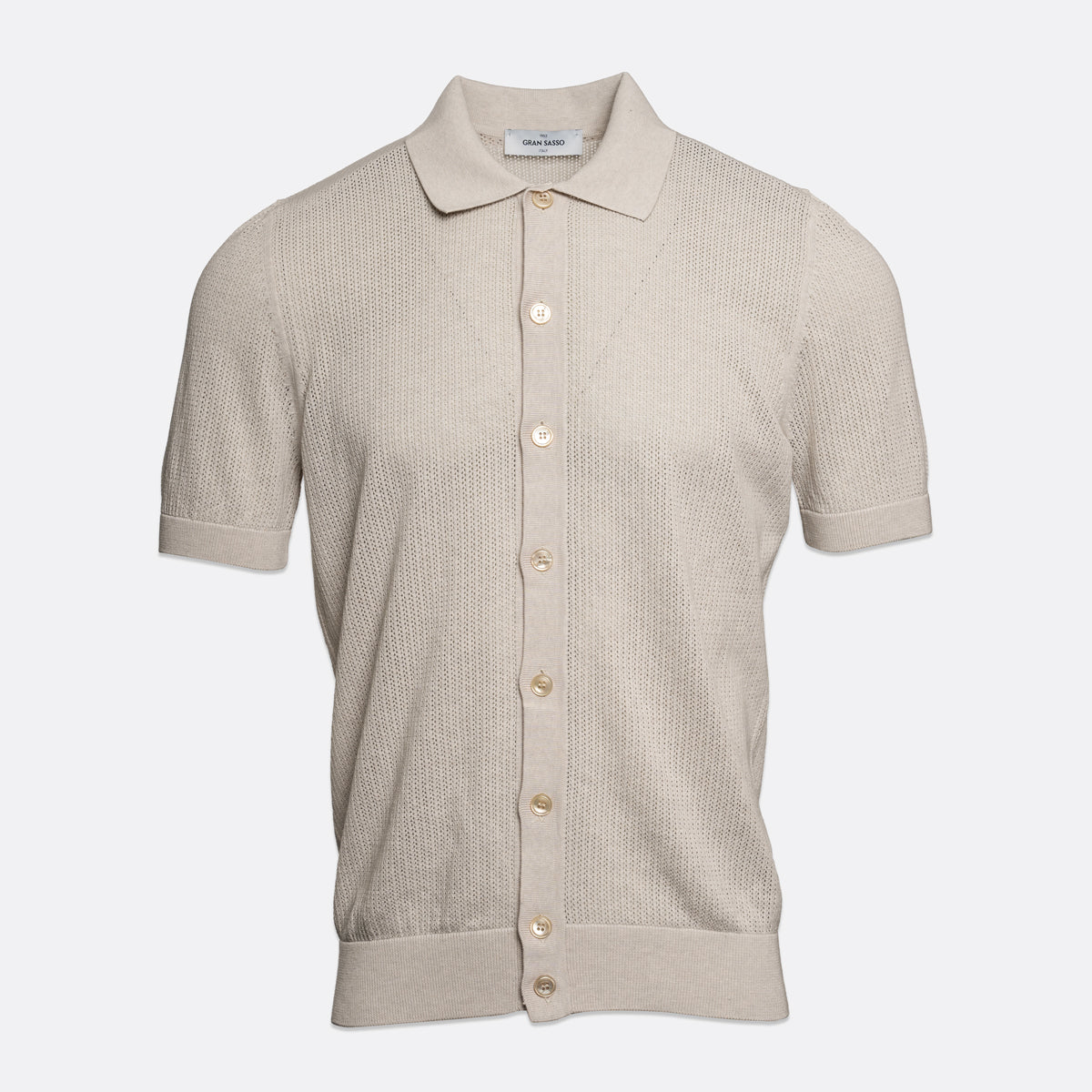 A light beige short-sleeve knit polo shirt with a textured waffle weave, button-down front, and a classic collar, shown on a light grey background. Gran Sasso Polo available at Sakks Menswear in Southampton.