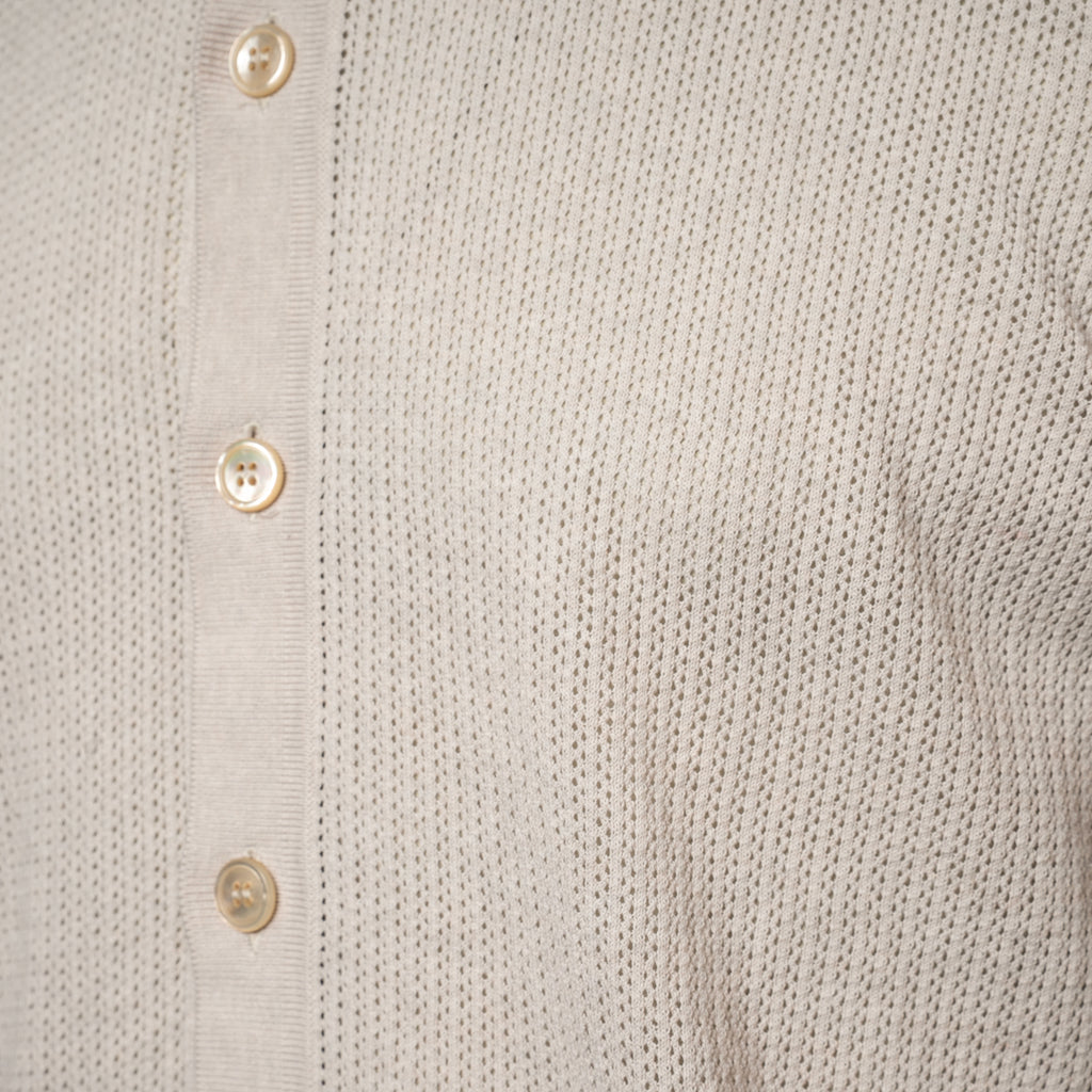 Close-up of a light beige knit shirt with a vertical button placket and cream-colored buttons. Gran Sasso Polo available at Sakks Menswear in Southampton.