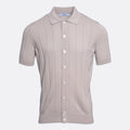A short-sleeve knit polo shirt in a light taupe-beige colour, featuring vertical ribbed texture and white buttons down the front, displayed on a clean light grey background. Gran Sasso Polo available at Sakks Menswear in Southampton.