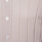 Close-up of a ribbed knit cardigan or sweater in a light warm beige or taupe colour, featuring a vertical button placket with white buttons. Gran Sasso Polo available at Sakks Menswear in Southampton.