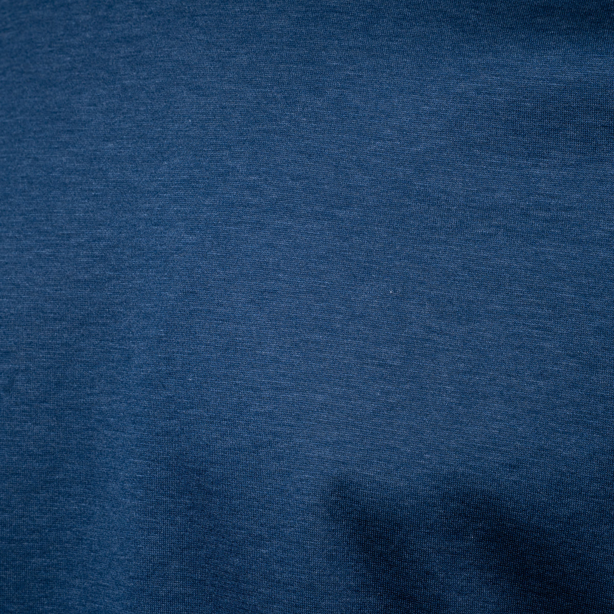 A close-up of dark blue heathered fabric texture filling the frame. Gran Sasso T-Shirt available at Sakks Menswear in Southampton.