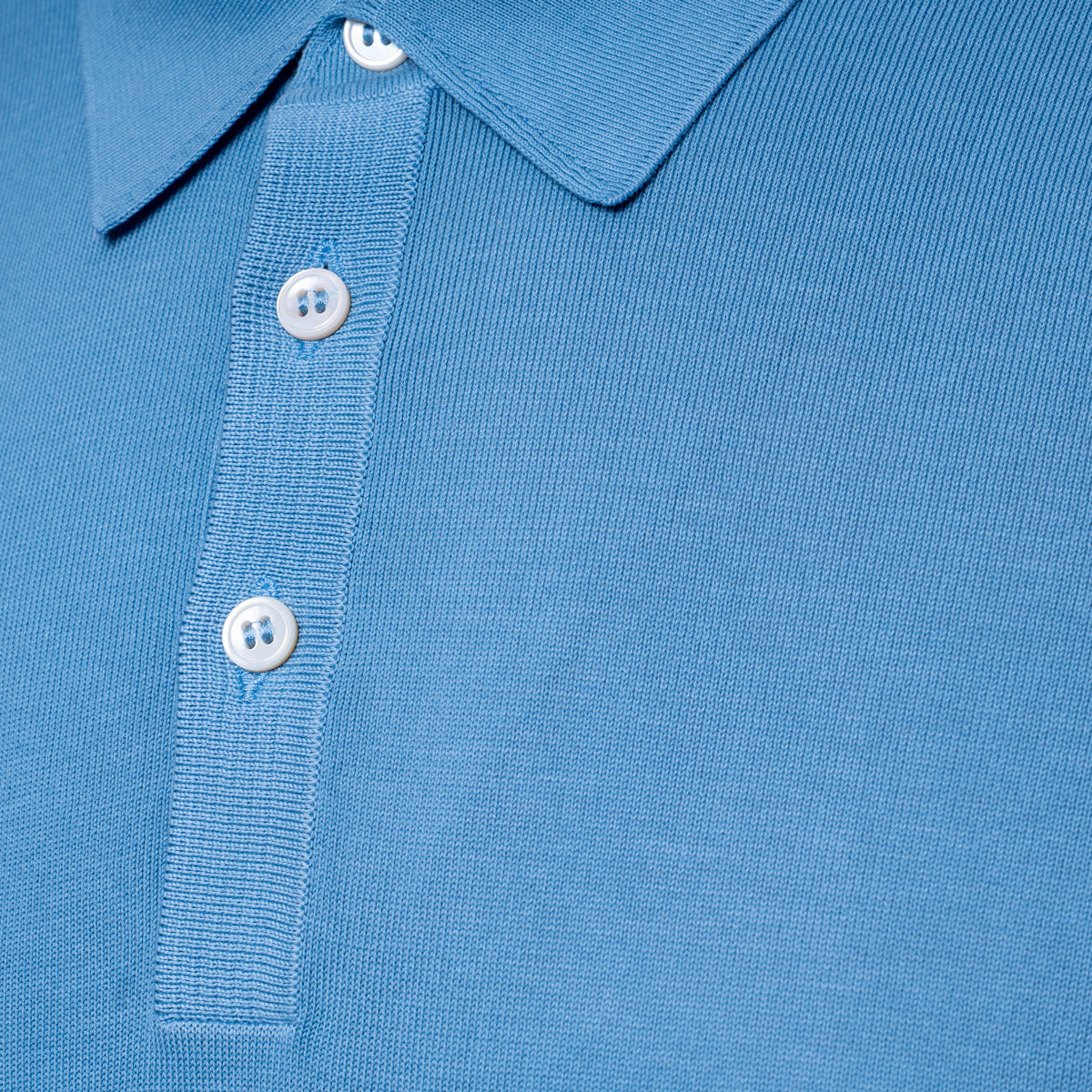 Close-up of a light blue polo shirt showing the collar, button placket, and ribbed fabric texture. Gran Sasso Polo available at Sakks Menswear in Southampton.