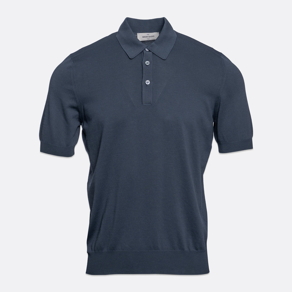 A short-sleeve polo shirt in a dark slate blue colour, displayed on a clean, light grey background. Gran Sasso Polo available at Sakks Menswear in Southampton.
