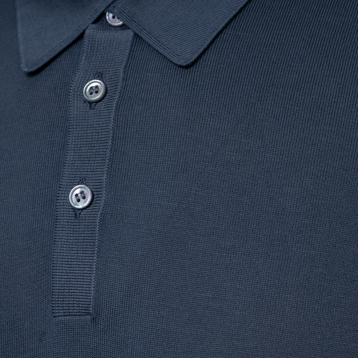 Close-up of a grey polo shirt showing the collar, ribbed placket, and silver buttons. Gran Sasso Polo available at Sakks Menswear in Southampton.