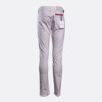 A pair of light gray slim-fit trousers shown from the back, featuring a white paper tag in the back pocket and a red accent tab on the waistband, set against a plain light gray background. Jacob Cohën Chinos available at Sakks Menswear in Southampton.