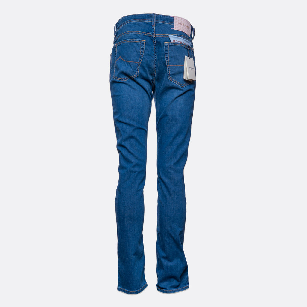 Blue denim jeans shown from the back, featuring a straight-to-flared leg, classic five-pocket design, and a white paper tag attached to the back right pocket, set against a plain light gray background. Jacob Cohën Jeans available at Sakks Menswear in Southampton.