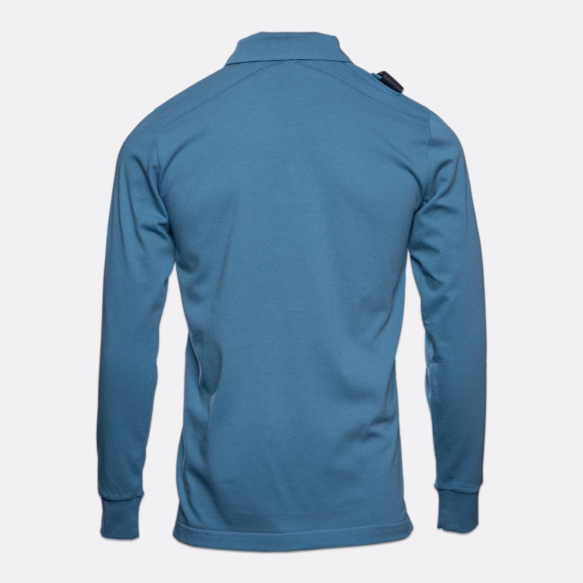 A blue long-sleeve athletic shirt shown from the back, featuring a collar and a small black tag on the upper right shoulder, set against a plain light gray background. MA.Strum Polo available at Sakks Menswear in Southampton.