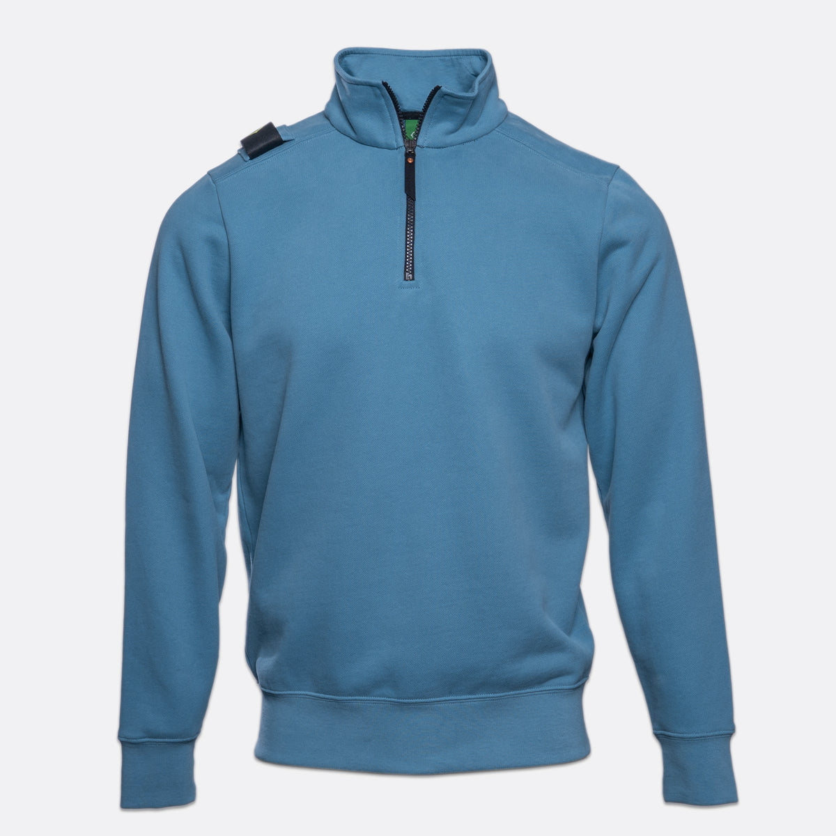 A blue long-sleeve quarter-zip sweatshirt with a mock neck, ribbed cuffs and hem, and a small black shoulder tab, shown on a light gray background. MA.Strum Sweatshirt available at Sakks Menswear in Southampton.