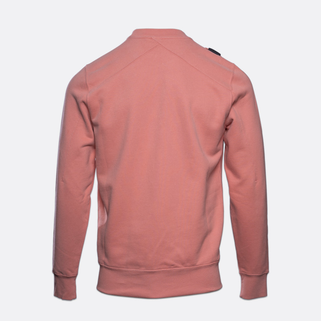 A dusty rose pink long-sleeve crewneck sweatshirt shown from the back, featuring a subtle diagonal seam across the upper back and ribbed cuffs and hem, set against a plain light gray background. MA.Strum Sweatshirt available at Sakks Menswear in Southampton.