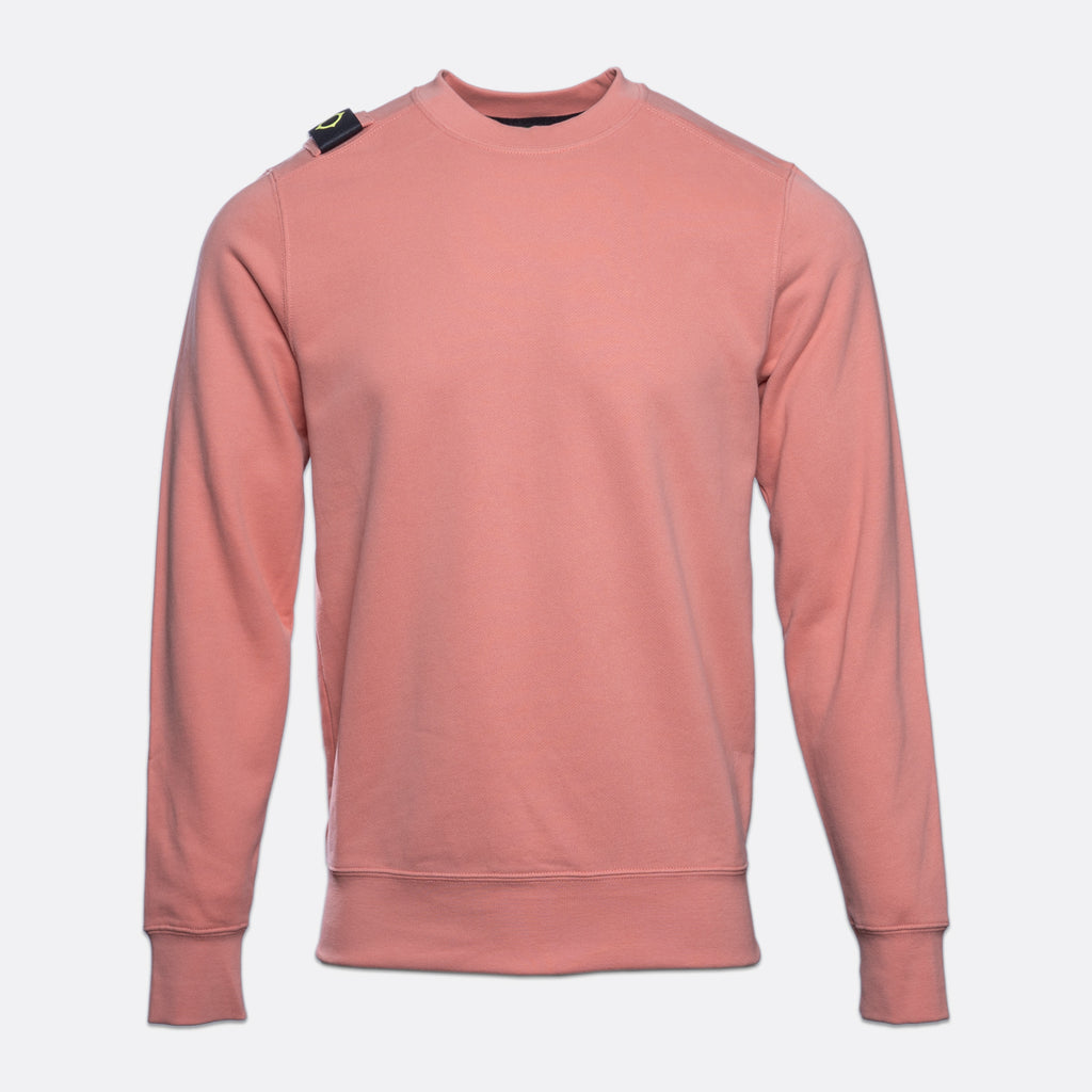 A dusty rose crewneck sweatshirt with a small black and green tag on the left shoulder, displayed on a light gray background. MA.Strum Sweatshirt available at Sakks Menswear in Southampton.