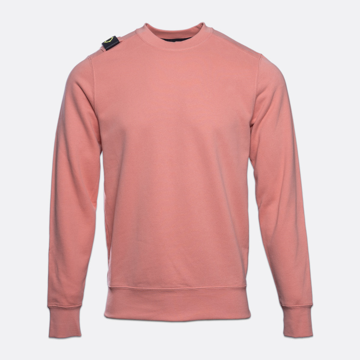 A dusty rose crewneck sweatshirt with a small black and green tag on the left shoulder, displayed on a light gray background. MA.Strum Sweatshirt available at Sakks Menswear in Southampton.