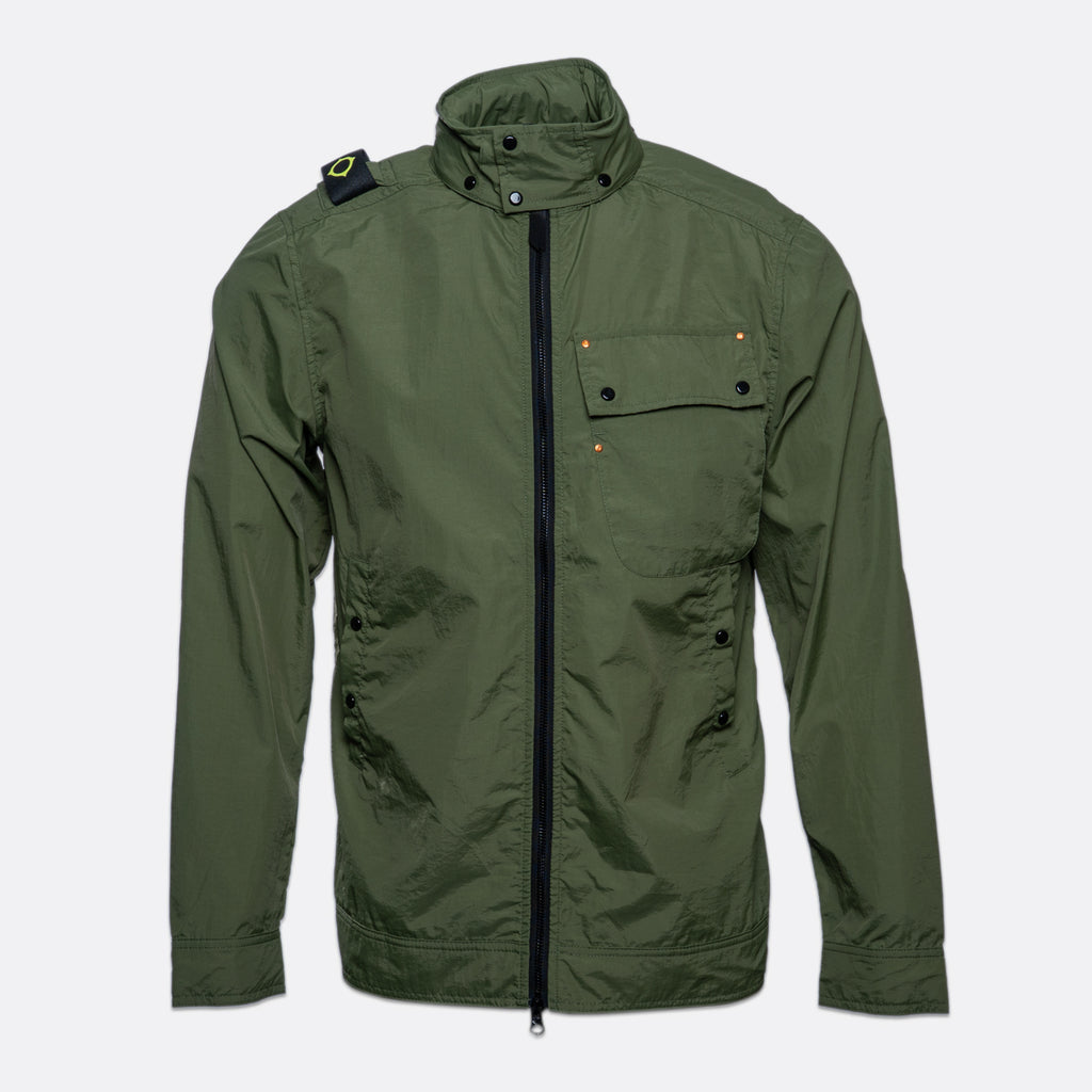 An olive green utility jacket with a high stand-up collar, black front zipper, and flap chest pocket, shown against a light gray background. MA.Strum Jacket available at Sakks Menswear in Southampton.