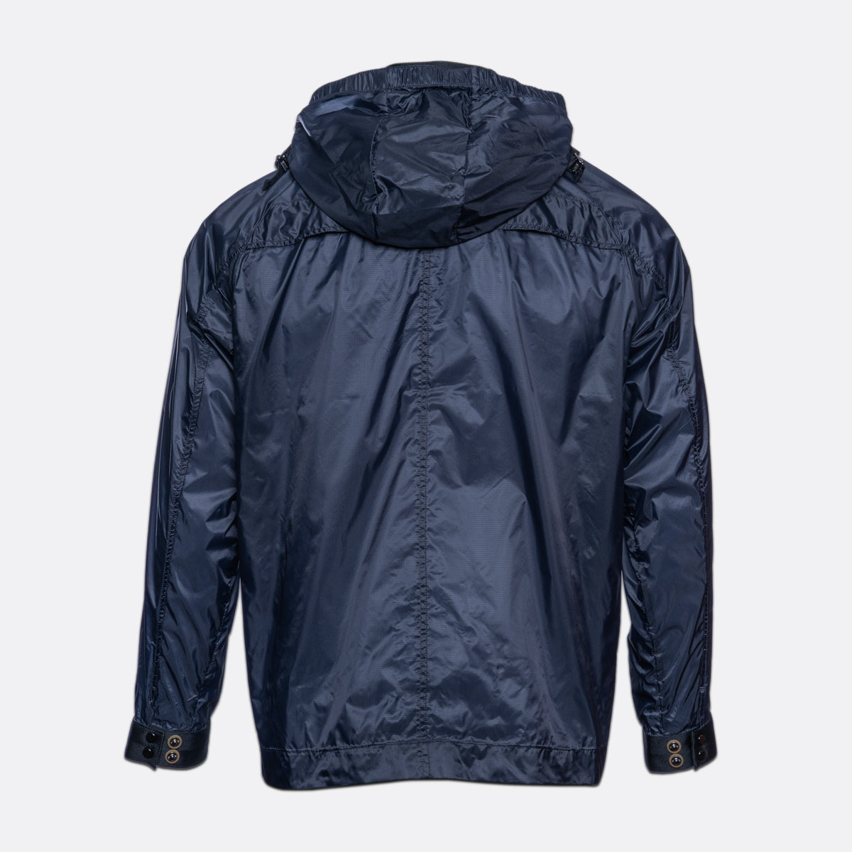 A navy blue hooded jacket shown from the back, featuring a smooth, slightly glossy nylon-like fabric and adjustable button cuffs, set against a plain light gray background. MA.Strum Jacket available at Sakks Menswear in Southampton.