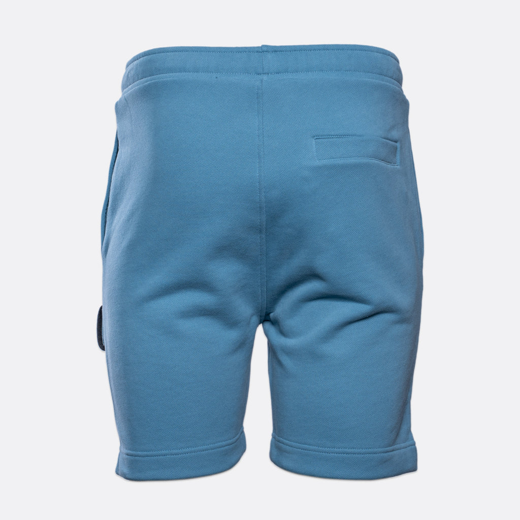 Blue sweat shorts shown from the back, featuring an elastic waistband, side pockets, and a welt pocket on the upper right leg, photographed against a light gray background. MA.Strum Sweat Shorts available at Sakks Menswear in Southampton.