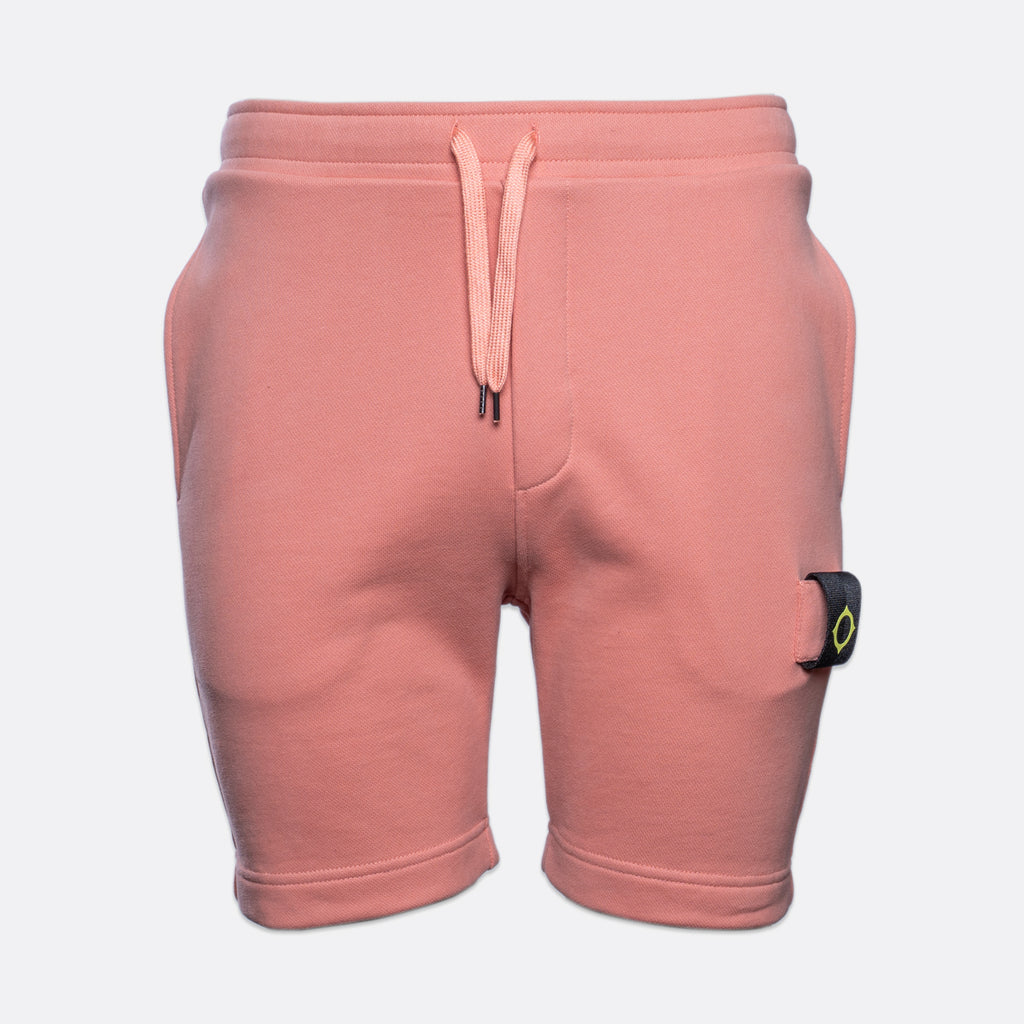 A pair of dusty pink sweat shorts with a matching drawstring waist and a signature Stone Island brand patch on the left leg, shown against a light gray background. MA.Strum Sweat Shorts available at Sakks Menswear in Southampton.