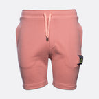 A pair of dusty pink sweat shorts with a matching drawstring waist and a signature Stone Island brand patch on the left leg, shown against a light gray background. MA.Strum Sweat Shorts available at Sakks Menswear in Southampton.