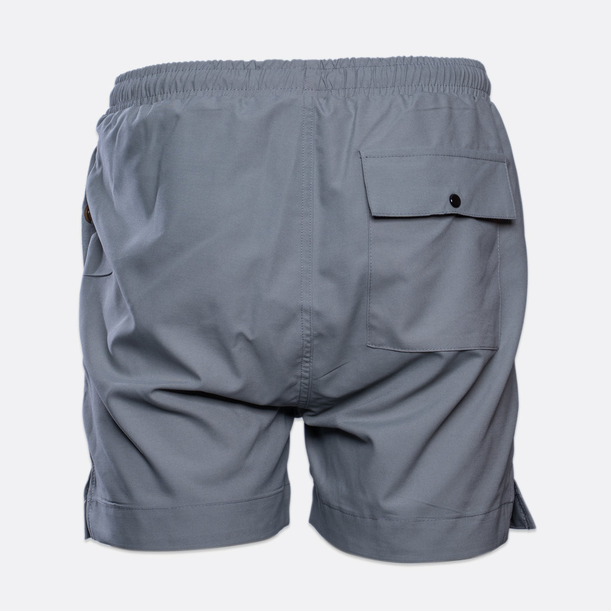 Gray athletic shorts shown from the back, featuring an elastic waistband, a side pocket with a button flap, and a side slit on the right leg, set against a plain light gray background. MA.Strum Swimwear available at Sakks Menswear in Southampton.