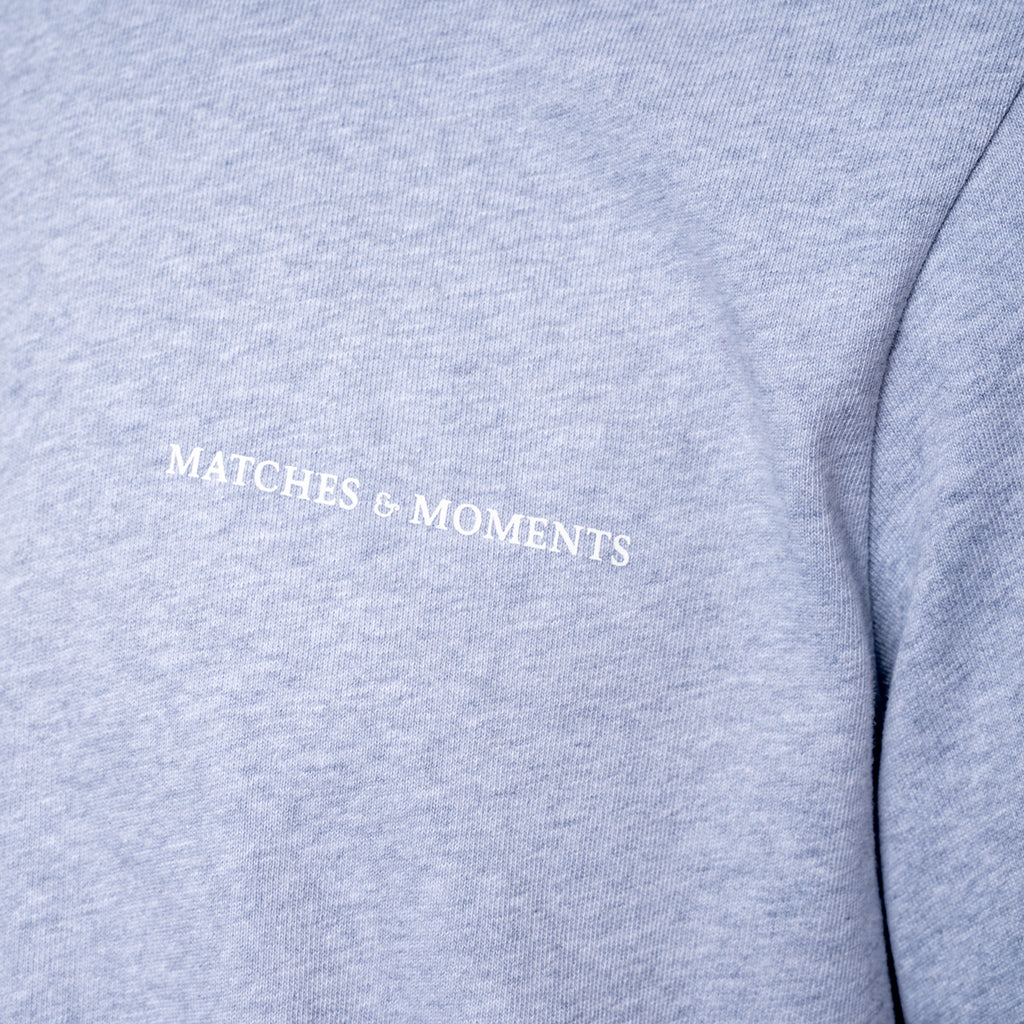 Close-up of a heather gray sweatshirt with the words 'MATCHES & MOMENTS' printed in white across the chest. PAIGE T-Shirt available at Sakks Menswear in Southampton.