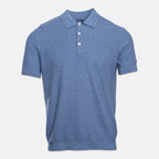 A short-sleeve polo shirt in a textured blue fabric, featuring a two-button placket and white buttons, displayed on a light gray background. PAIGE Polo available at Sakks Menswear in Southampton.