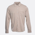 A long-sleeve button-up shirt in a light taupe-beige color, featuring a pointed collar, a single chest pocket, and white buttons, shown against a light gray background. PAIGE Shirt available at Sakks Menswear in Southampton.