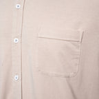 Close-up of a light beige or cream-colored short-sleeve button-up shirt with a chest pocket and white  PAIGE Shirt available at Sakks Menswear in Southampton.buttons.