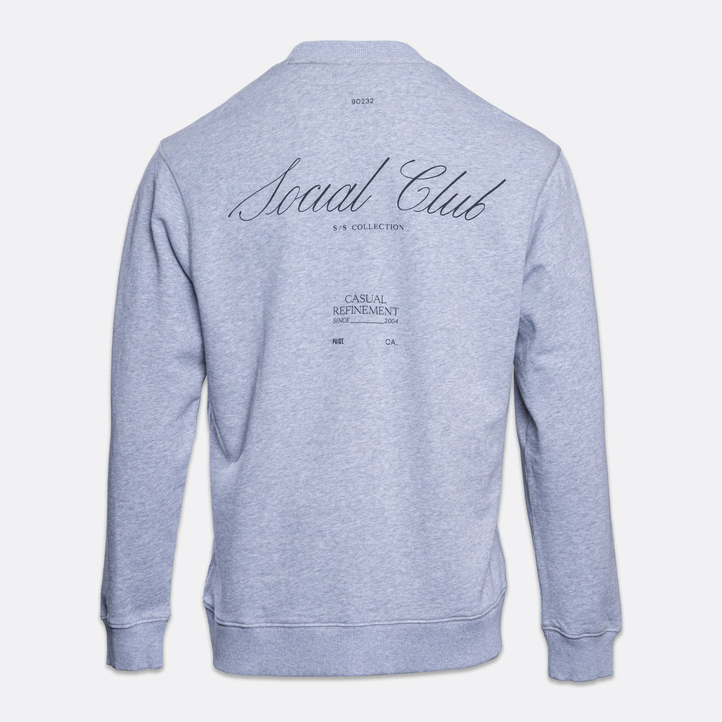 A light heather gray sweatshirt shown from the back, featuring 'Social Club' printed in a black cursive font with 'S.S.'. PAIGE Sweatshirt available at Sakks Menswear in Southampton.