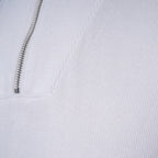 Close-up of a white textured knit garment with a silver metal zipper running vertically. PAIGE Sweatshirt available at Sakks Menswear in Southampton.