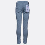 A pair of slim-fit blue jeans shown from the back, featuring a white paper tag attached to the back pocket, set against a plain light gray background. Replay Chinos available at Sakks Menswear in Southampton.