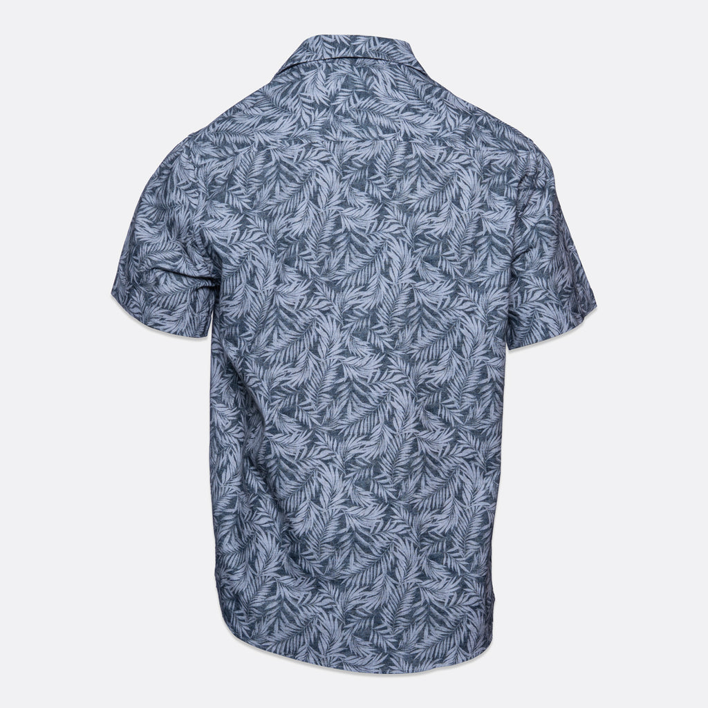 Short-sleeve button-up camp shirt with an all-over blue and gray tropical palm leaf pattern, shown from the back on a light gray background. Sand Copenhagen Short Sleeve Shirt available at Sakks Menswear in Southampton.