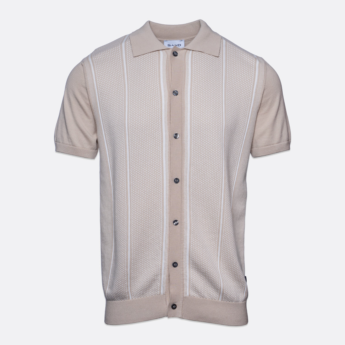 A short-sleeve knit polo shirt in a light beige color, featuring vertical textured stripes and a button-up front, shown against a plain light gray background. Sand Copenhagen Polo available at Sakks Menswear in Southampton.